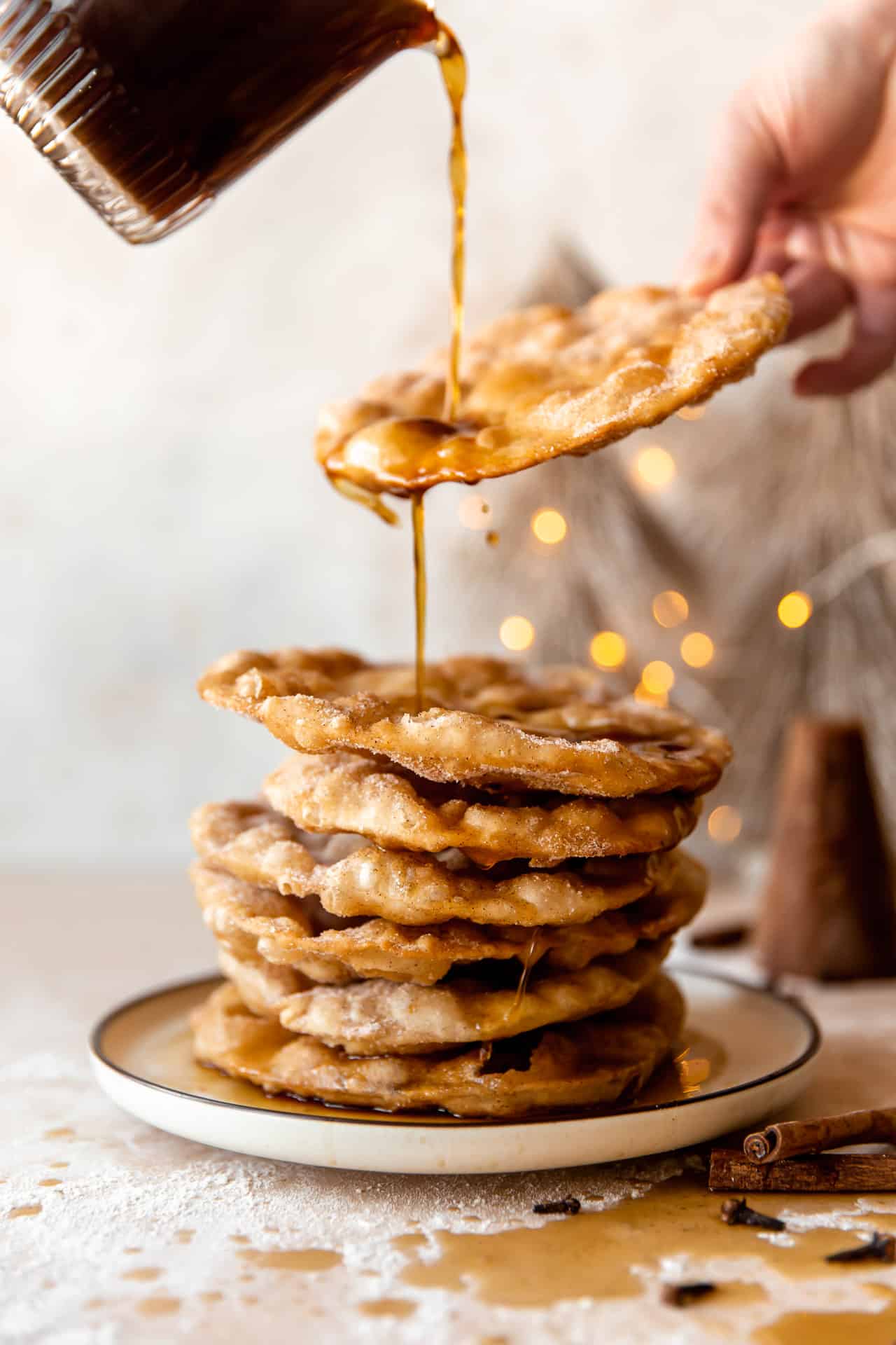 在一叠刚炸好的 bunuelos 上淋上 Piloncillo 糖浆。